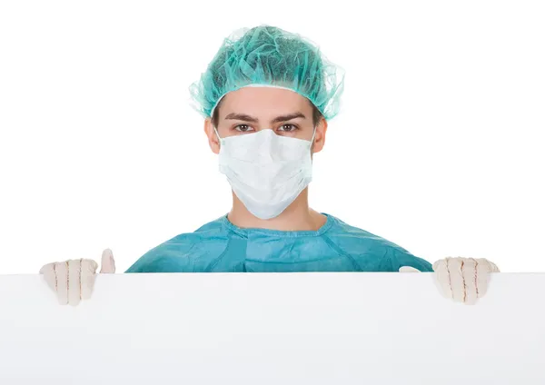 Surgeon holding up a blank banner — Stock Photo, Image