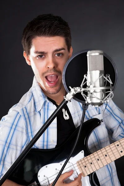 Mladý zpěvák s mikrofonem — Stock fotografie