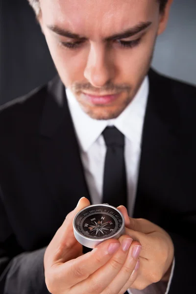 Businessman looking at a compass — Stock Photo, Image