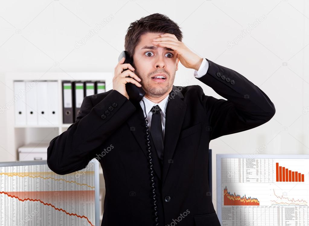 Worried stock broker on the phone
