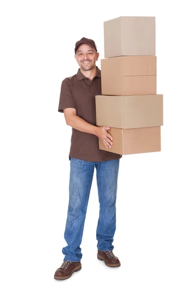Homem feliz segurando pilha de caixas de cartão — Fotografia de Stock