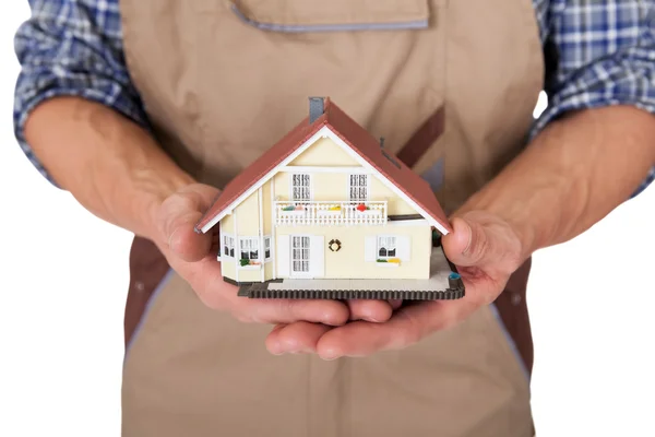 Trabalhador da construção apresentando modelo de casa — Fotografia de Stock