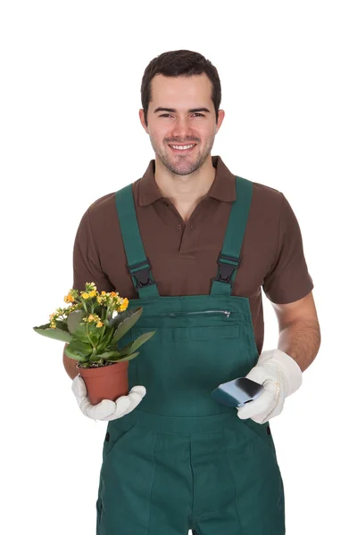 Jovem jardineiro feliz segurando flores — Fotografia de Stock