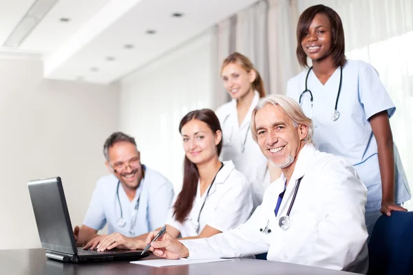 Atractiva doctora trabajando en su portátil —  Fotos de Stock