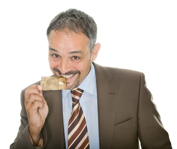 Mature businessman bites his credit card — Stock Photo, Image