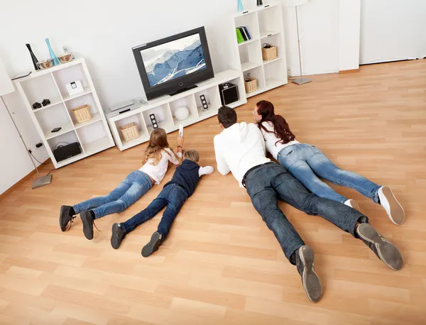 年轻的家庭，在家里看电视 — 图库照片
