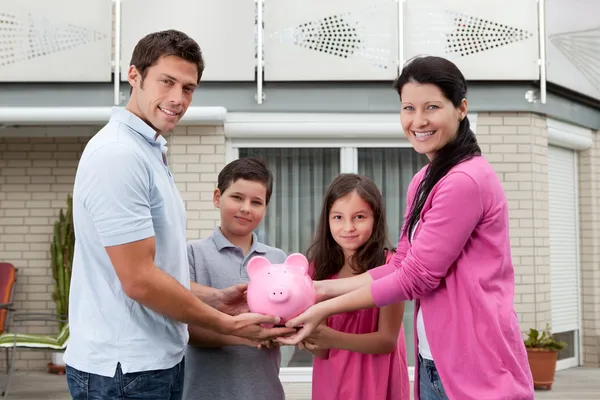 節約のコンセプト - ピギー銀行との幸せな家族 — ストック写真