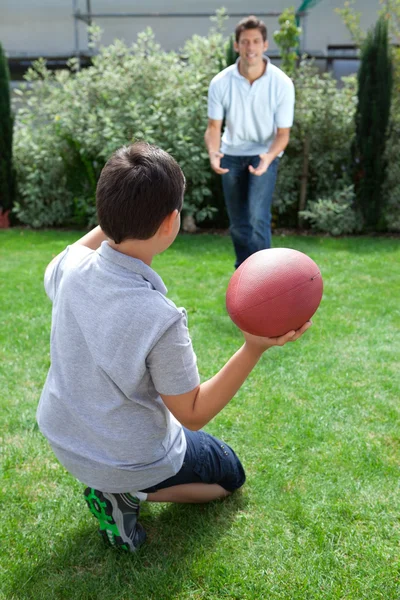 Far och son som spelar amerikansk fotboll — Stockfoto