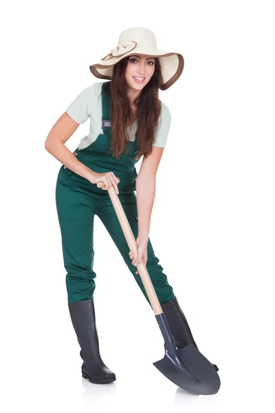Mooie vrouw bedrijf plant en tuinieren shovel — Stockfoto