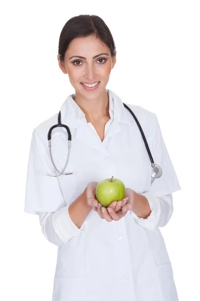 Νεαρή γυναίκα γιατρό κρατώντας πράσινο μήλο — Φωτογραφία Αρχείου