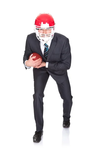 Конкурентный бизнесмен, играющий в американский футбол — стоковое фото