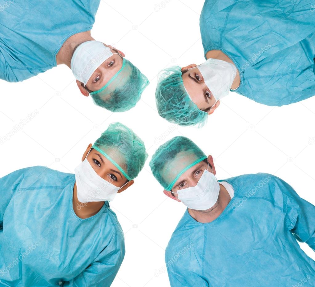 Four surgeon looking down at patient