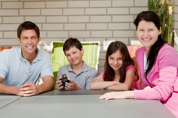 Szczęśliwa rodzina siedzi razem w podwórku — Zdjęcie stockowe