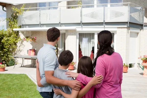 Rüya evlerinin önünde genç aile ayakta — Stok fotoğraf