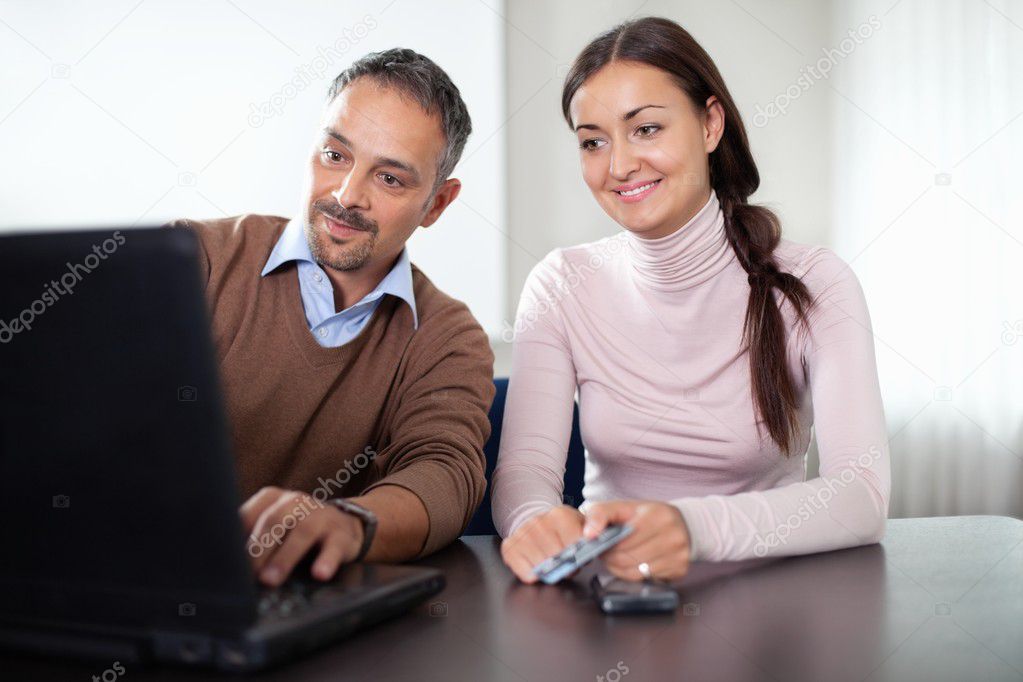 Beautiful woman sitting with a man using laptop
