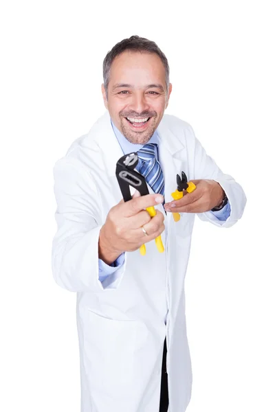 Улыбающийся доктор, держащий щипцы — стоковое фото