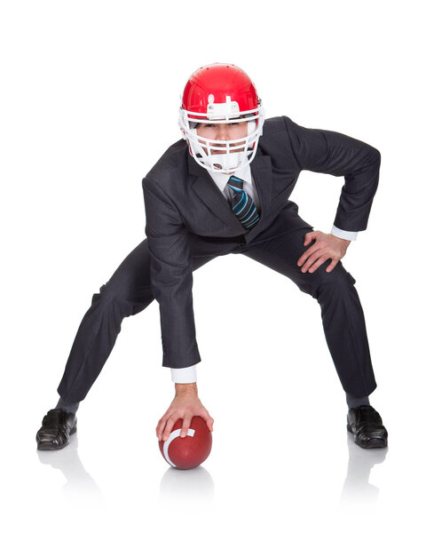 Competitive businessman playing american football