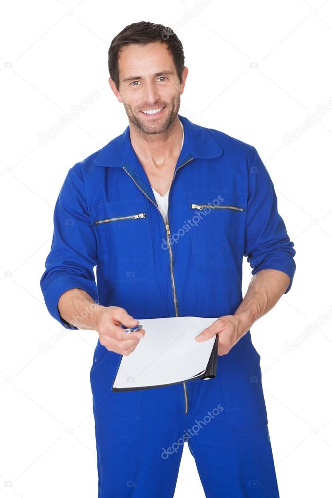 Portrait of happy automechanic writing invoice