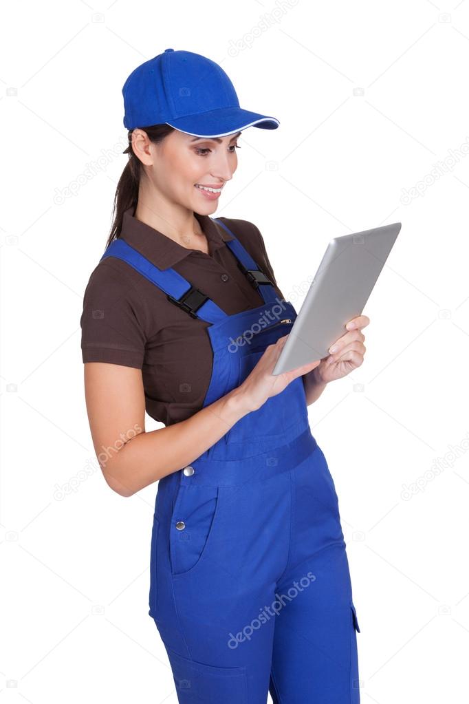 Smiling Female Plumber Working On Digital Tablet