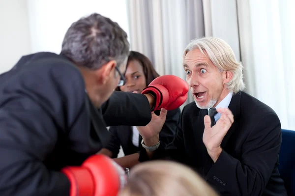 Team of business associates fighting in the office — Stock Photo, Image