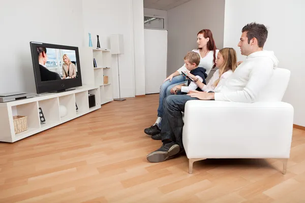 Joven familia viendo la televisión en casa Imagen De Stock