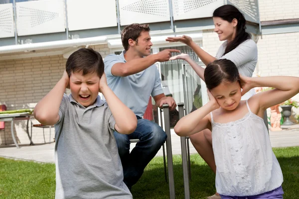 I bambini soffrono mentre i genitori combattono in background — Foto Stock