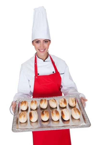 Vrouwelijke baker bedrijf vers brood — Stockfoto