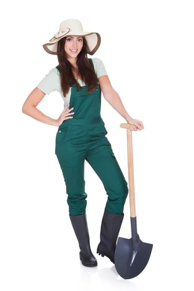 Hermosa mujer sosteniendo la planta y la pala de jardinería — Foto de Stock