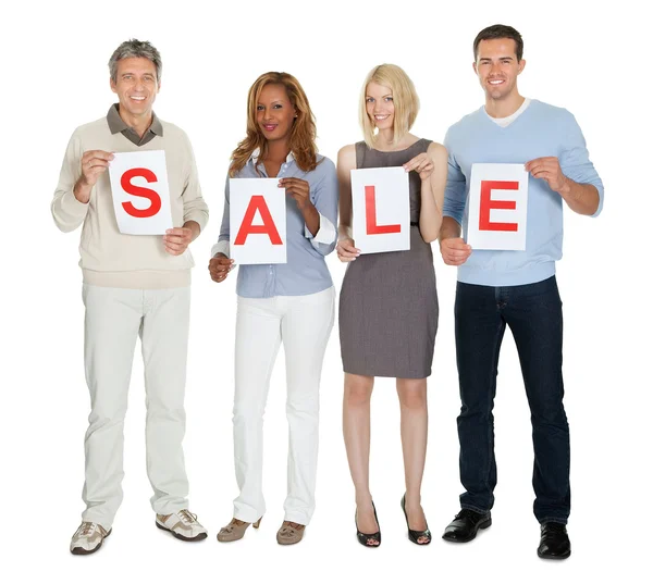 Businesspeople holding white paper with word sale — Stock Photo, Image