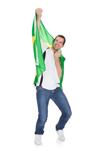 Retrato de un hombre feliz sosteniendo una bandera brasileña — Foto de Stock