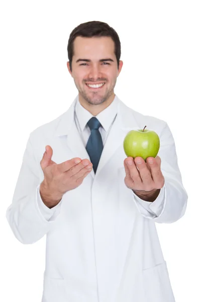 Médico masculino segurando maçã verde — Fotografia de Stock