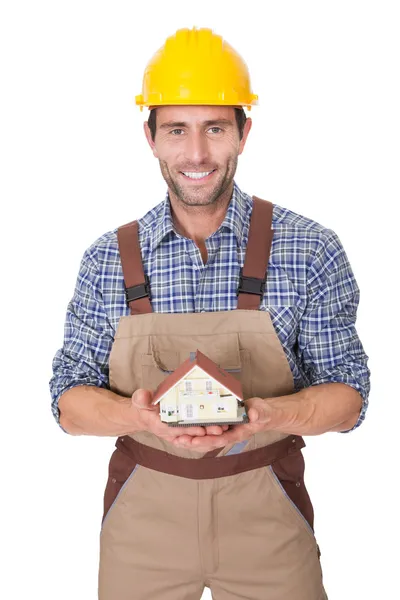 Construction worker presenting house model — Stock Photo, Image