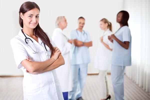 Женщина-врач с коллегами на заднем плане — стоковое фото
