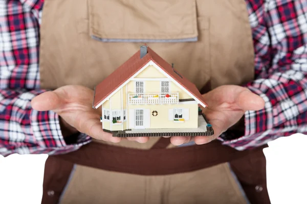 Construction worker holding house model — Stock Photo, Image