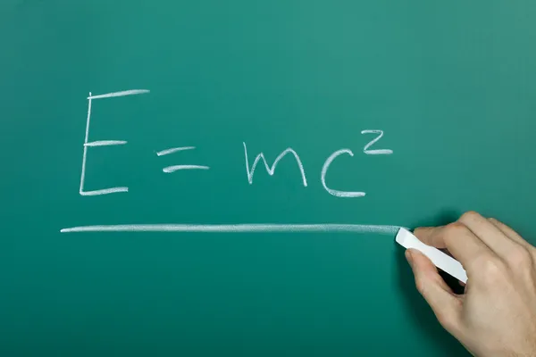 Hand writing relativity formula on green blackboard — Stock Photo, Image