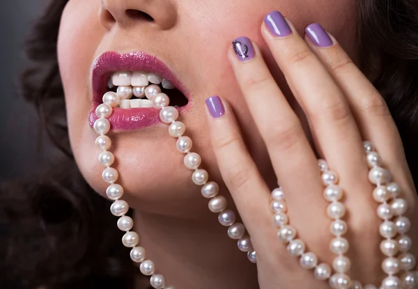 Hermosa mujer joven sosteniendo collar de perlas — Foto de Stock