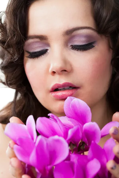 Молода жінка тримає пурпурні квіти — стокове фото