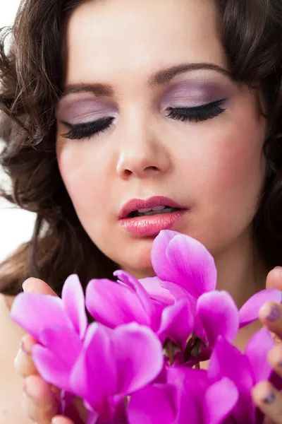 Jovem mulher segurando flores roxas — Fotografia de Stock