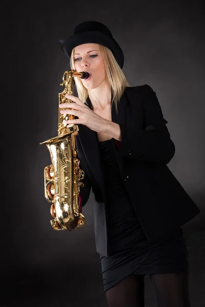 Schöne junge Frau spielt Saxophon — Stockfoto