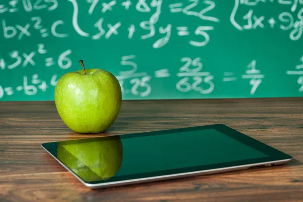 Tablet und Apfel auf dem Schreibtisch — Stockfoto