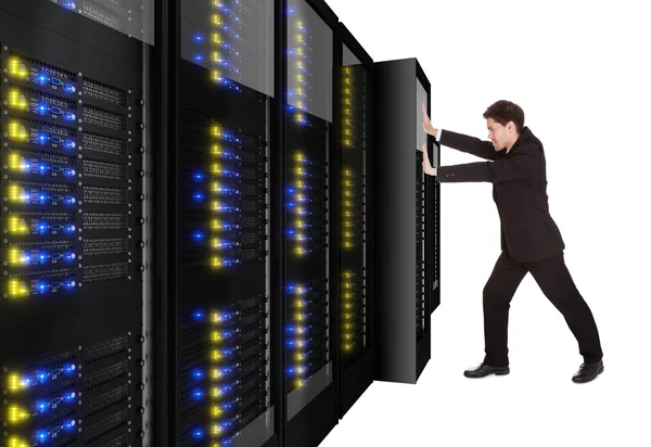 Empresário empurrando rack de servidor no lugar — Fotografia de Stock