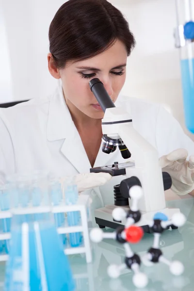 Cientista feminina olhando através do microscópio — Fotografia de Stock