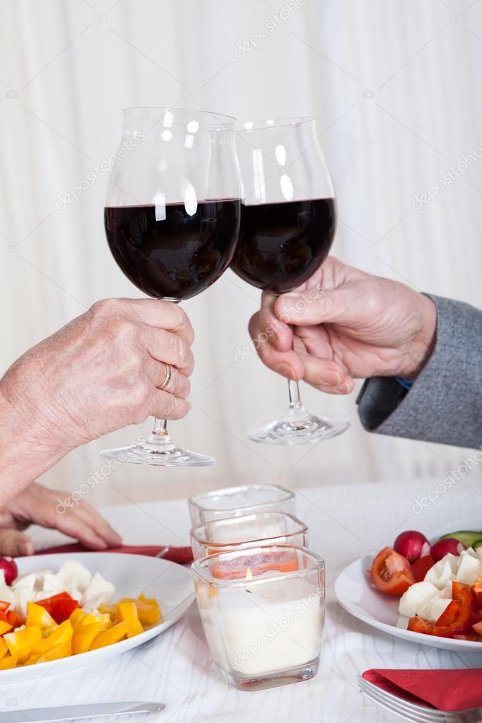 Close-up Of Hands Toasting Wine Glasses