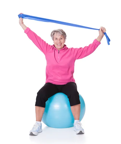 Seniorin streckt Trainingsgerät — Stockfoto