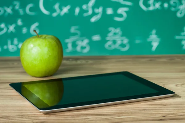 Tablet und Apfel auf dem Schreibtisch — Stockfoto