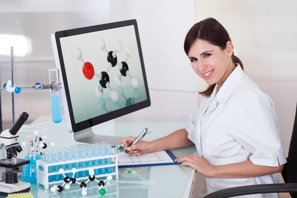 Científica femenina escribiendo en bloc de notas — Foto de Stock