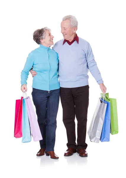 Casal sênior segurando sacos de compras — Fotografia de Stock