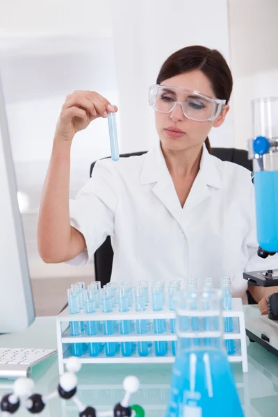 Vrouwelijke onderzoeker bedrijf in een reageerbuis — Stockfoto