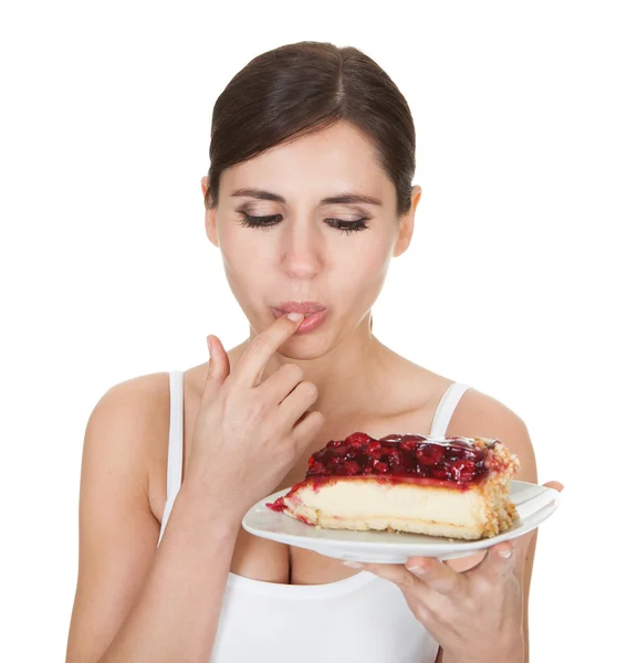 Genç kadın pasta tatmak — Stok fotoğraf
