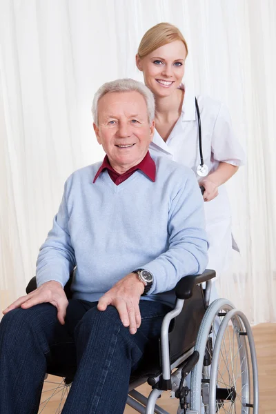 Medico curante che aiuta il paziente handicappato — Foto Stock